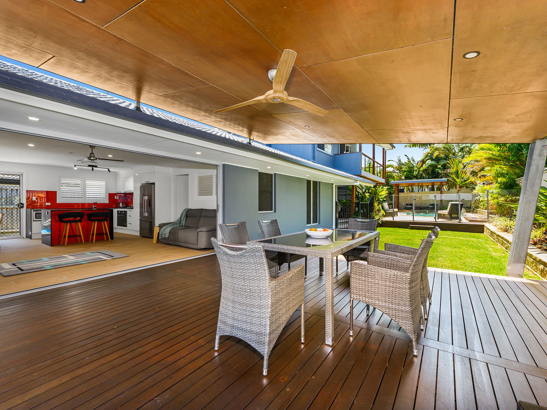 The kitchen's expansive open-plan dining area boasts a huge 6-meter concertina door that opens the room to reveal a raised outdoor dining deck with a 50s-inspired slanted roof.